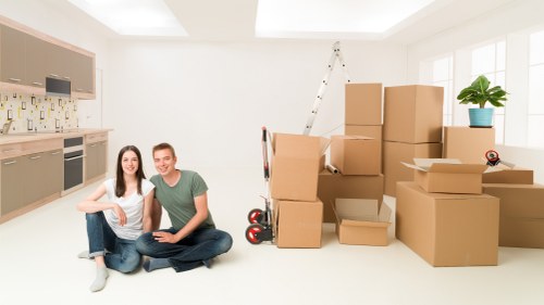 Removal company worker carrying a packed box indoors